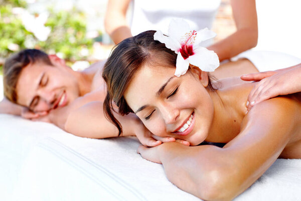 Feeling the stress melt away. Attractive young couple enjoying a massage at the spa
