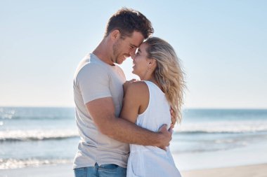 Çift, yaz tatili için plajda aşk ve sarılma ilişkisi ya da açık havada romantik bir bağ. Mutlu adam ve kadın gülüşleriyle okyanusta romantizm için kucaklaşıyorlar..