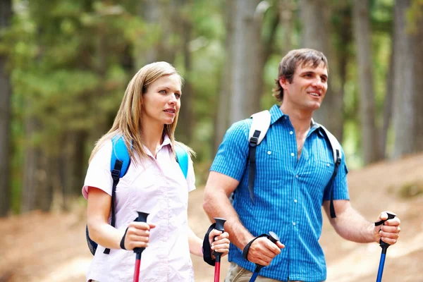 カップルハイキング バックパック付きのかわいいカップルハイキングポールと歩く — ストック写真