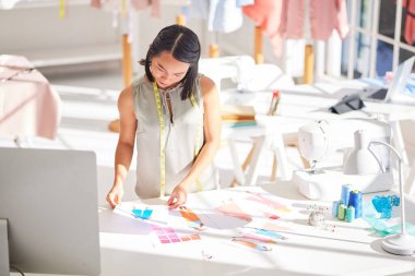 Moda, tasarımcı ve iş kadını tasarım stüdyosunda yaratıcı koleksiyon üzerinde çalışıyor, düşünüyor ve planlıyor. Sadece Tokyo 'da renk, tarz ve kumaş seçen Asyalı, işyeri sahibi ve giyim uzmanı.