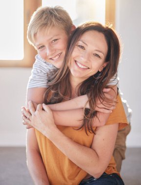 Anne, bir aile evinde kucak kucak ve çocuk mutluluk, bağ ve aile bakımıyla birlikte. Bir anne ve çocuğun portresi. Sevgi dolu ve mutlu bir evde. Gülümseyen ve sarılan bir çocuk..