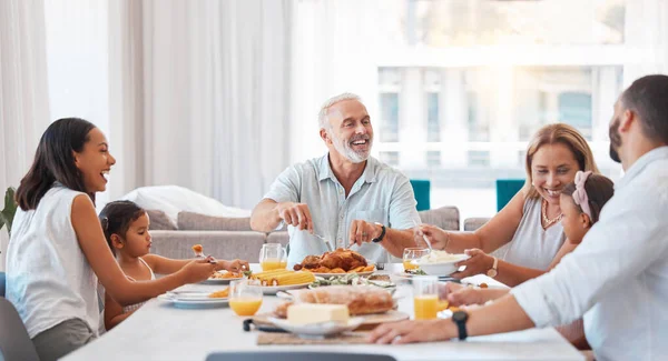 Family, happy and eating together with food and drink on table, celebrate holiday or anniversary and dining room. Love, celebration and nutrition, grandparents with parents and children at home