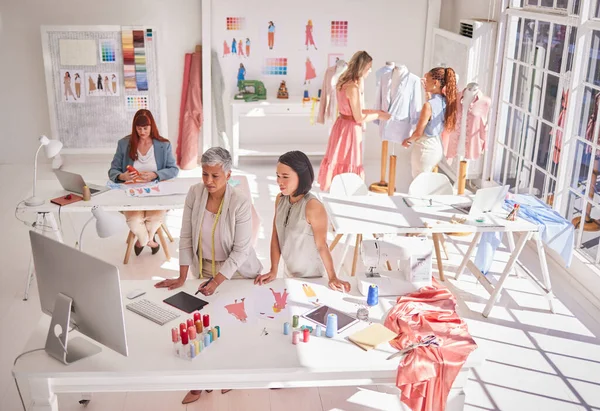 Clothes production, designer and women working on fashion, fabric and textile planning work. Creative studio busy with idea, style innovation and creativity design with collaboration and teamwork.