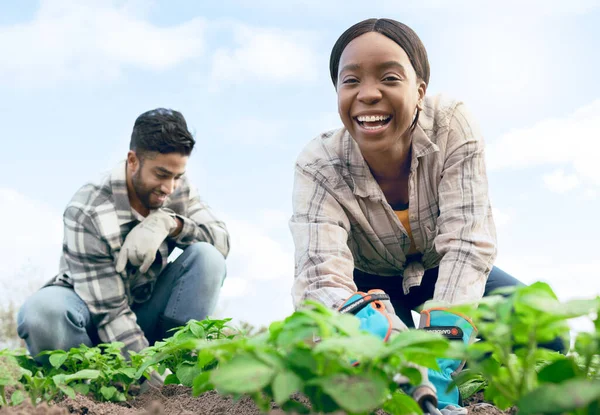 Farmer, gardening and agriculture portrait in field with happy black woman and indian man working. Nature, soil and interracial farming people on vegetable produce farm together with low angle