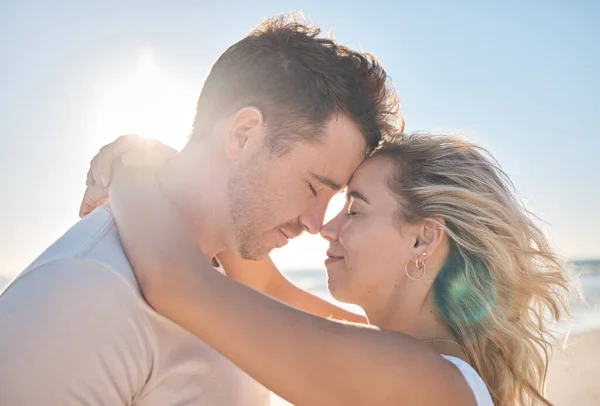 Beach hug, couple love and forehead touching of husband and wife on honeymoon vacation in Toronto Canada. Blue sky flare, freedom peace and marriage partnership bond of man and woman on romantic date.