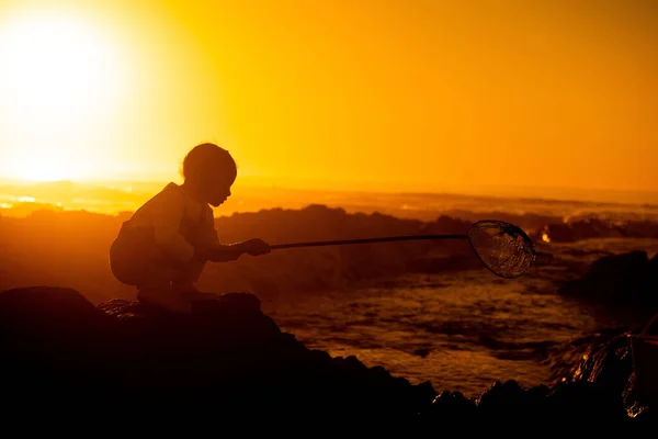 Pôr Sol Silhueta Criança Uma Rocha Praia Brincando Pescando Com — Fotografia de Stock
