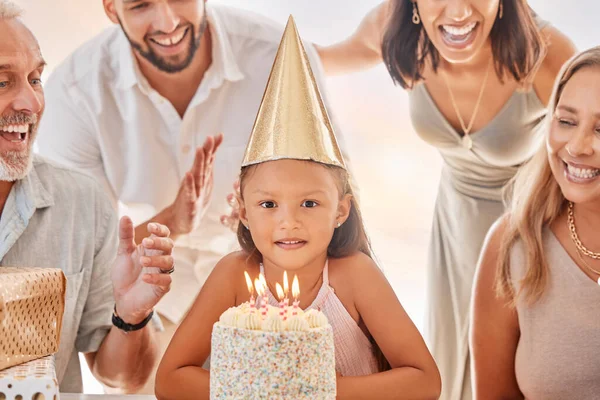 Birthday, candles on birthday cake and child with big family celebrate party event, sing together and show girl love in apartment home. Happy mother, father and child bonding with grandparents smile.