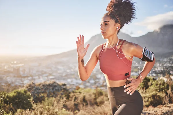 Fitness, music and mountain with black woman running with phone for health, training and sports. Streaming, technology and mobile with girl runner for exercise, freedom and workout in nature.