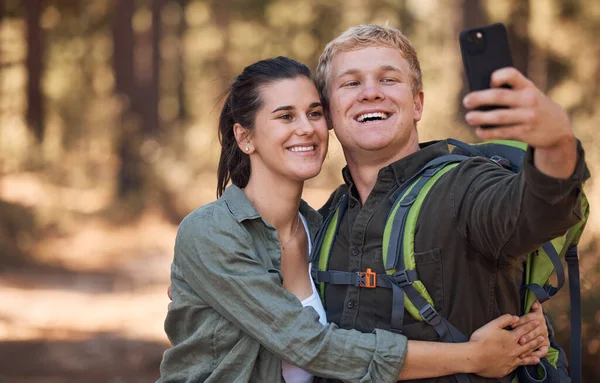 Stock image Couple, phone selfie and hiking in nature on holiday or summer vacation. Travel, man and woman enjoying quality time together with 5g mobile smartphone on social media, picture post or happy memory