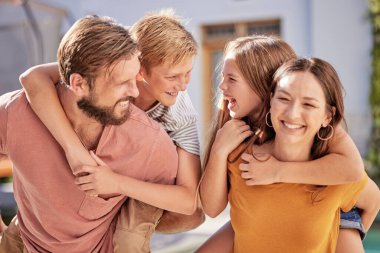 Mutlu aile ve çocuklar, mutlu ve neşeli bir bahçede bir araya gelip gülüyor ve eğleniyorlar. Aile, çocuklar ve babayla birlikte neşeli anne hafta sonları eğlenmek için arka bahçede..