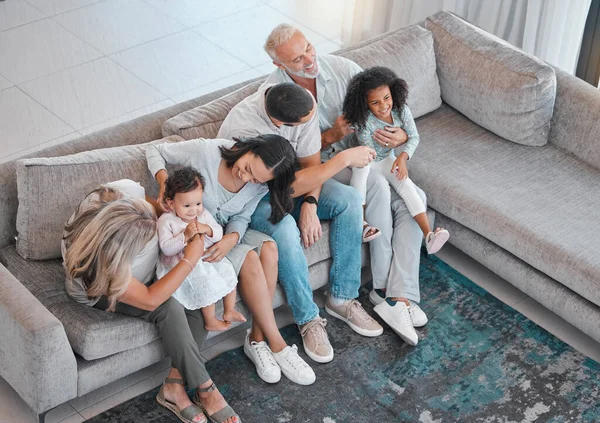 Happy family, children or parents bonding with senior grandparents on sofa in house or home living room. Top view, men or women with kids, girls and retirement elderly people together on lounge couch.