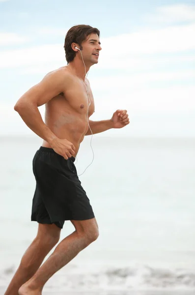 Melodie Ćwiczeń Przystojny Młody Mężczyzna Idący Biegać Plaży Podczas Słuchania — Zdjęcie stockowe