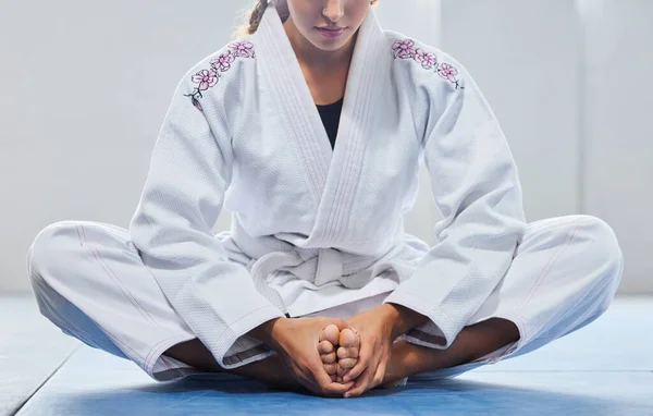Warm up, legs and woman in karate training, learning martial arts and focus before a fight. Fitness, performance and feet of girl in taekwondo class for body power, self defense and start of exercise.