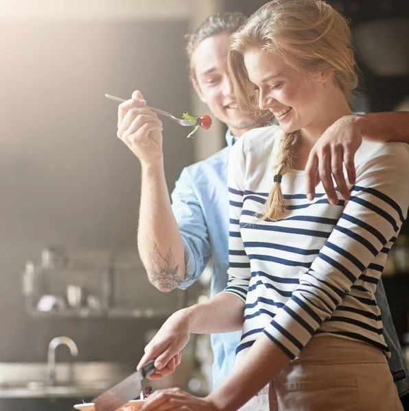 Stock image Feeding her with his love. a young man feeding his girlfriend some of the salad shes preparing