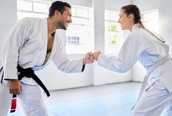 Karate, motivation and fist bump with a man and woman fighter training together in a gym or dojo. Fitness, exercise and fight with a male and female athlete in a health club for combat sports.