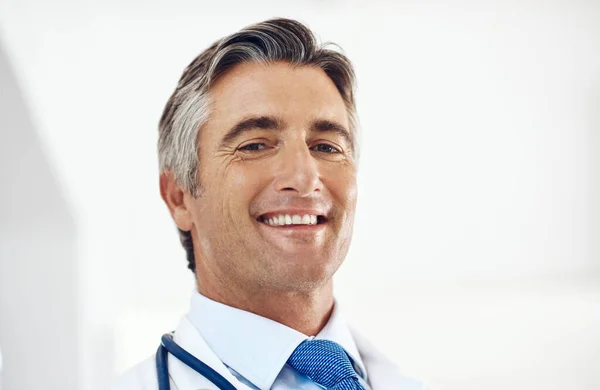 命を救うと笑顔になる 病院に立つハンサムな成熟した男性医師のトリミングされた肖像画 — ストック写真