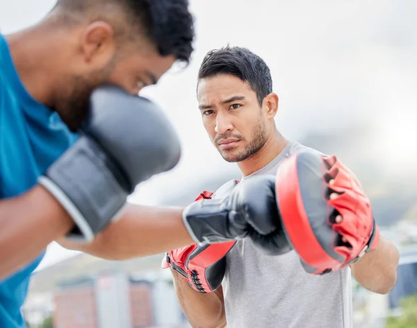 Fitness, personal trainer and boxing exercise for sports competition, training or self defense practice in the city. Boxer doing intense power workout with coach in preparation for competitive fight.