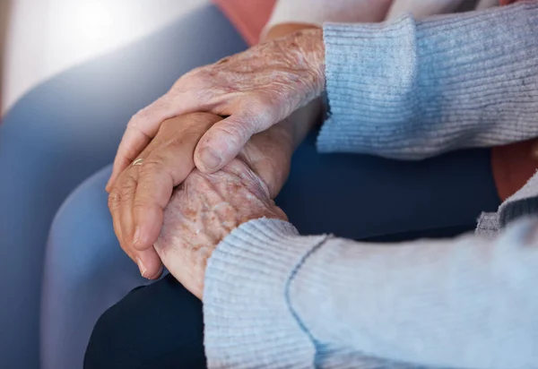 Holding hands, love and support in trust for elderly care, retirement or hope and respect at old age home. Senior hands touch in care, praying or comfort for help, reliable or community healthcare.