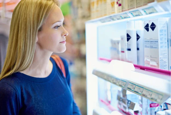 Theres so many options nowadays. a young woman browsing the shelves in a pharmacy