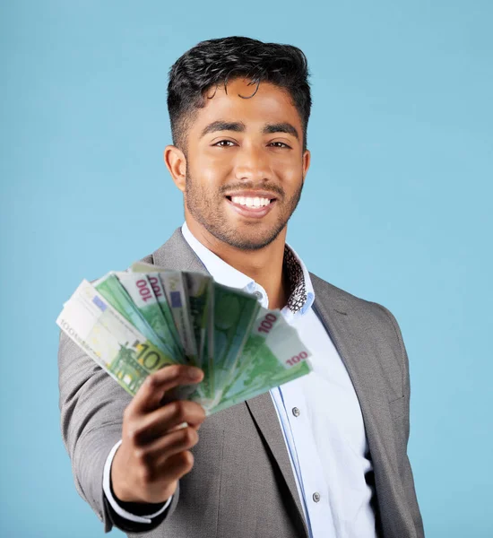 Businessman, money and rich with cash, income and happy with profit, salary and finance currency in blue mockup studio background. Investment, male employee or working in economy or financial growth.