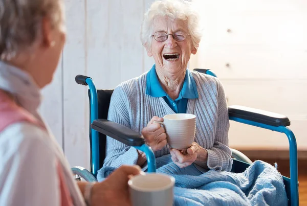 高齢者の女性 障害者やリハビリテーションのための車椅子の中で友人やコーヒーや紅茶や面白い会話や冗談について幸せや笑い 老人ホームで一緒に楽しみのために — ストック写真
