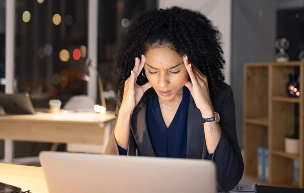 Work stress, headache and black woman working on a office computer at night on business deadline. Anxiety, burnout and head pain from professional stress and fatigue with technology and email.