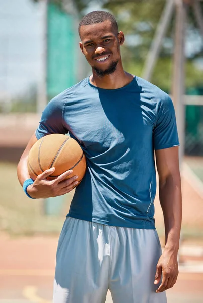 Basketball player, black man portrait and outdoor sports court training, workout and game in New York, USA. Happy professional male athlete, basketball court and ball, community playground and action.