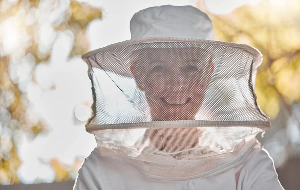 Beekeeper, woman and protective suit in portrait, happy and outddor with ppe, safety and agriculture. Senior bee farmer, happy and beekeeping at farm, backyard or nature to work in honey production.