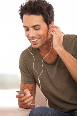 En sevdiğim şarkı. Yakışıklı bir genç adam mp3 çalarda müzik dinliyor.