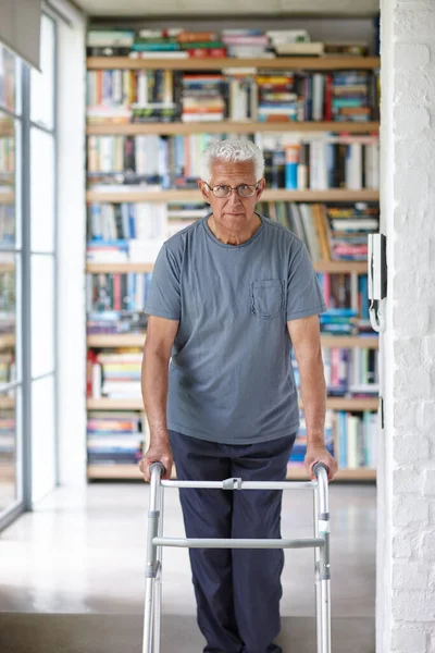 On the move with the help of a walker. Portrait of a senior man standing with the assistance of a walker indoors
