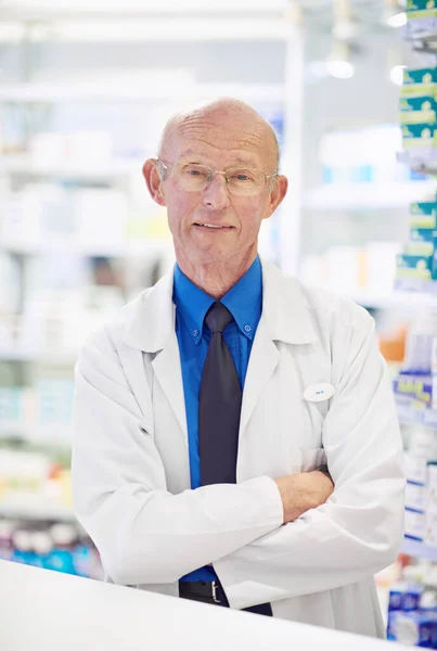 Hes here to help with years of expertise. Portrait of a senior pharmacist working at a counter