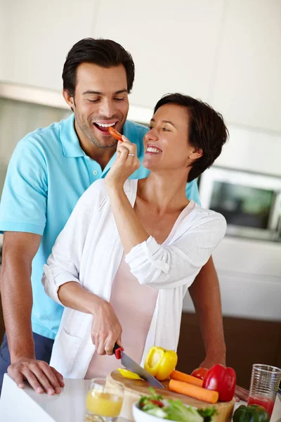 彼を幸せにするために彼に軽食を与える 夫に野菜を噛まれた女がカウンターで切り刻む — ストック写真