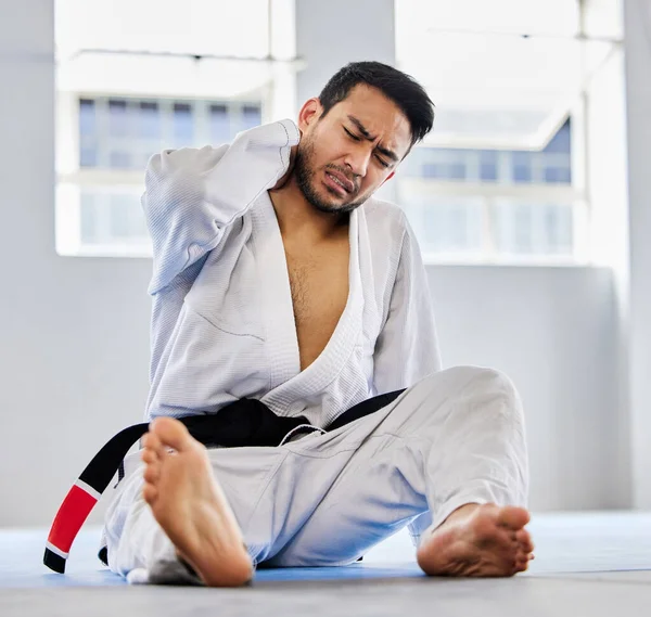Karate, sports injury and neck pain in health gym for healthcare, medical accident and exercise training emergency. Fitness athlete, martial arts wellness and workout burnout in health club floor.