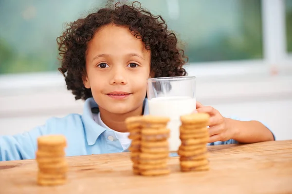 Mmm, so many cookies just for me. A cute young boy grabbing a cookie from the cookie jar