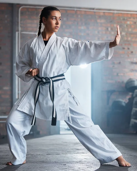 Karate training, fitness and woman in gym, healthcare motivation and strong focus for fight workout. Fist, sport exercise and healthy athlete person or martial arts wellness for taekwondo competition.