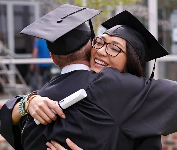 Graduation congratulations. two students hugging on graduation day