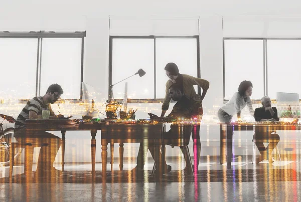 They dont know 9-5. Multiple exposure shot of colleagues working in a modern office superimposed over a city background