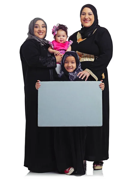 我们有很多话要说 一个穆斯林家庭的女性成员举着一个白色的空白标志的工作室肖像 — 图库照片