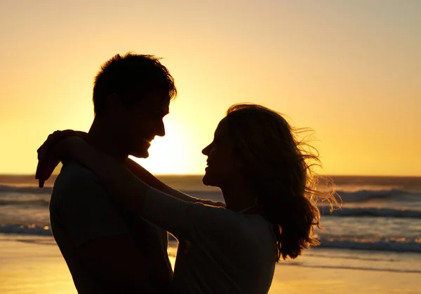 私を完成させた 夕暮れ時にビーチでお互いの目を見つめ合うカップルのロマンチックなショット — ストック写真