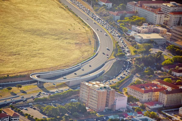 Dividing up city and green space. Aerial view of a highway running between green space and urban development