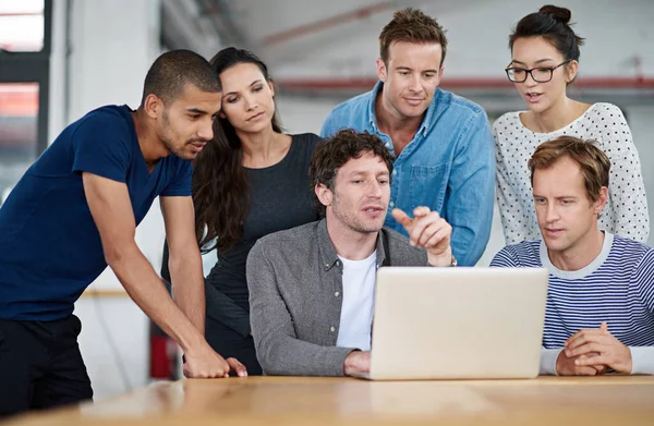 stock image Design in progress. a group of colleagues using a laptop together in a casual work environment