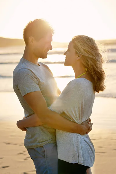しっかりつかまって離さないで ビーチで腰の周りで抱き合っているカップルが — ストック写真