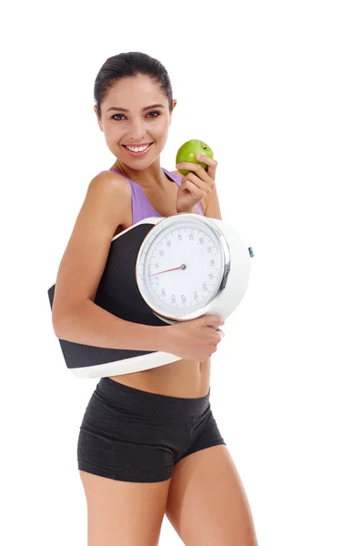 体重减轻很容易 一个穿着运动服 拿着苹果和秤的年轻貌美女子的演播室照片 — 图库照片