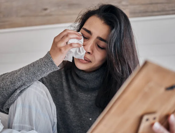 Crying, frame and woman with tissue, sad and upset for loss for difficult day. Mental health, young female or girl with tears for depression and grief for death, frustrated or problems after breakup.