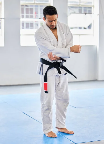 Karate injury, hurt and elbow pain for a man athlete holding painful arm at the gym. Active, Sport and athletic male suffering from muscle inflammation due to an exercise, fight training or workout.