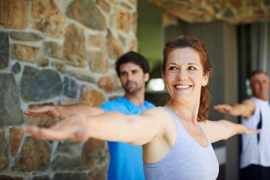 Daha iyi bir sağlığa doğru esniyorlar. Yetişkin bir kadın fitness dersinden zevk alıyor.