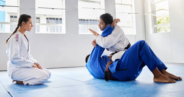 Karate, fitness and student learning from a teacher in a fighting workout, mma training or combat exercise. Sports, education and martial arts expert instructor coaching or teaching a girl or woman.