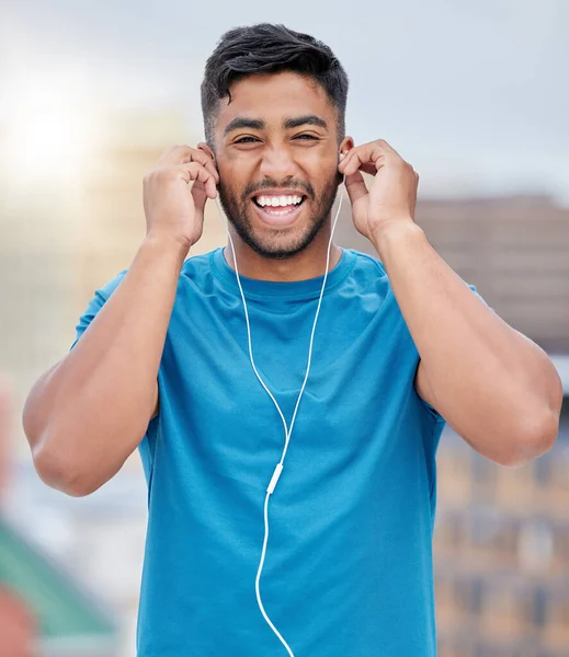 Stock image Fitness, earphones and wellness music portrait of athlete ready for outdoor triathlon training. Health, workout and happy smile of indian man getting ready for exercise with audio streaming