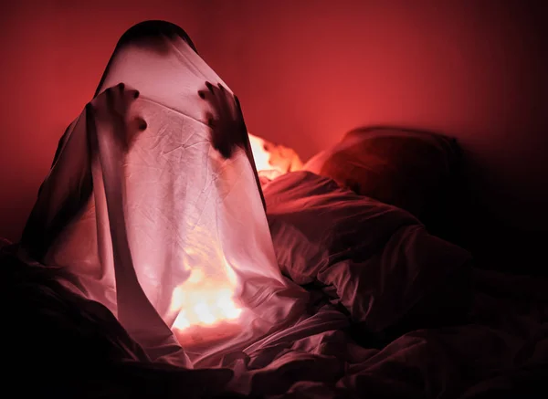 怖い話 恐怖と人間のシルエットと夜の悪のための寝室で幽霊 シートと赤の光 スリラー 気味の悪いと暗いのための不眠症の恐怖とハロウィーンの背景のための家のベッドルームの人 — ストック写真