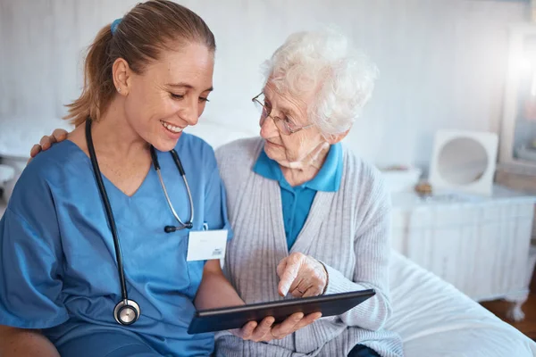 タブレット 看護師または医師は 血圧と心臓検査の結果を持つ老人ホームの寝室で老婦人に相談してください 幸せな医療従事者高齢者医療報告書 — ストック写真
